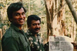 Prabhakaran Holding 'Daily News' Newspaper Featuring 'Prabhakaran Killed Rumour Sweeps the Country' (Below the Main Photo), Alongside PFLT General Secretary 'Yogi' Yogaratnam