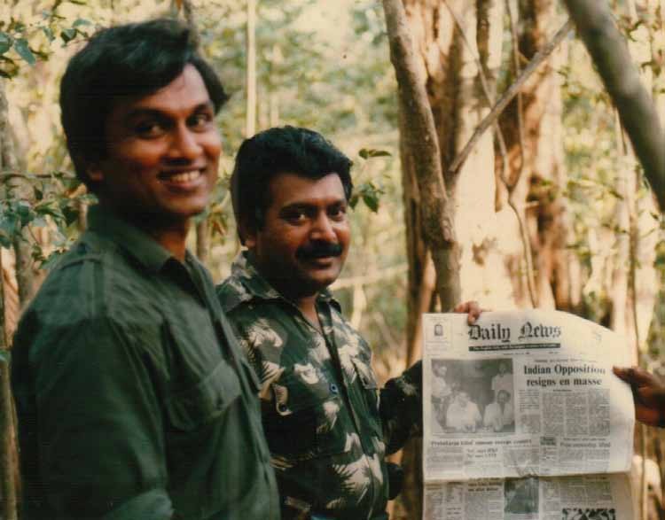 Prabhakaran Holding 'Daily News' Newspaper Featuring 'Prabhakaran Killed Rumour Sweeps the Country' (Below the Main Photo), Alongside PFLT General Secretary 'Yogi' Yogaratnam